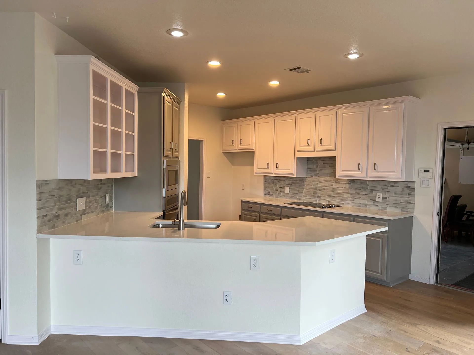 White kitchen with white cabinets, countertops, and backsplash.