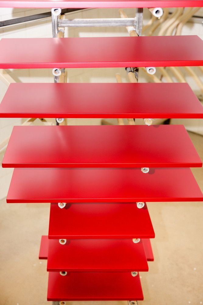 Eilė raudonų lentynų, sukrautų viena ant kitos