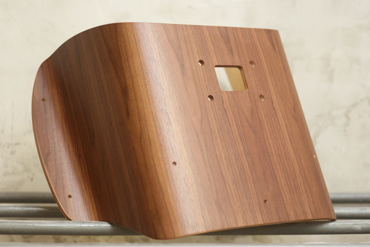 Ant metalinio turėklo sėdi medžio gabalas su skylutėmis.