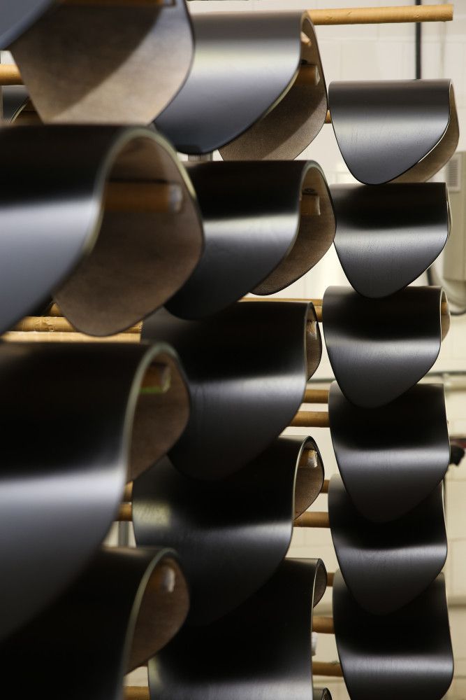 Juodai dažytų kėdžių sėdimų dalių sukrauta viena ant kitos