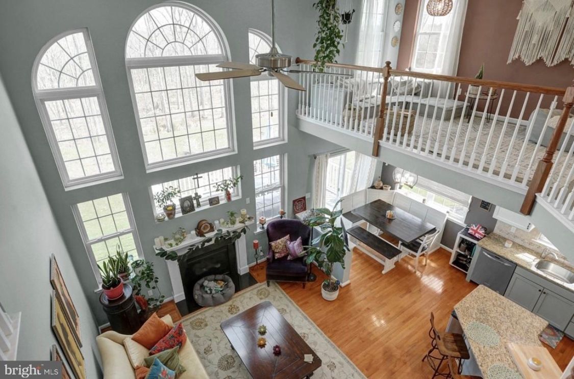 An aerial view of a living room with a fireplace and a balcony.