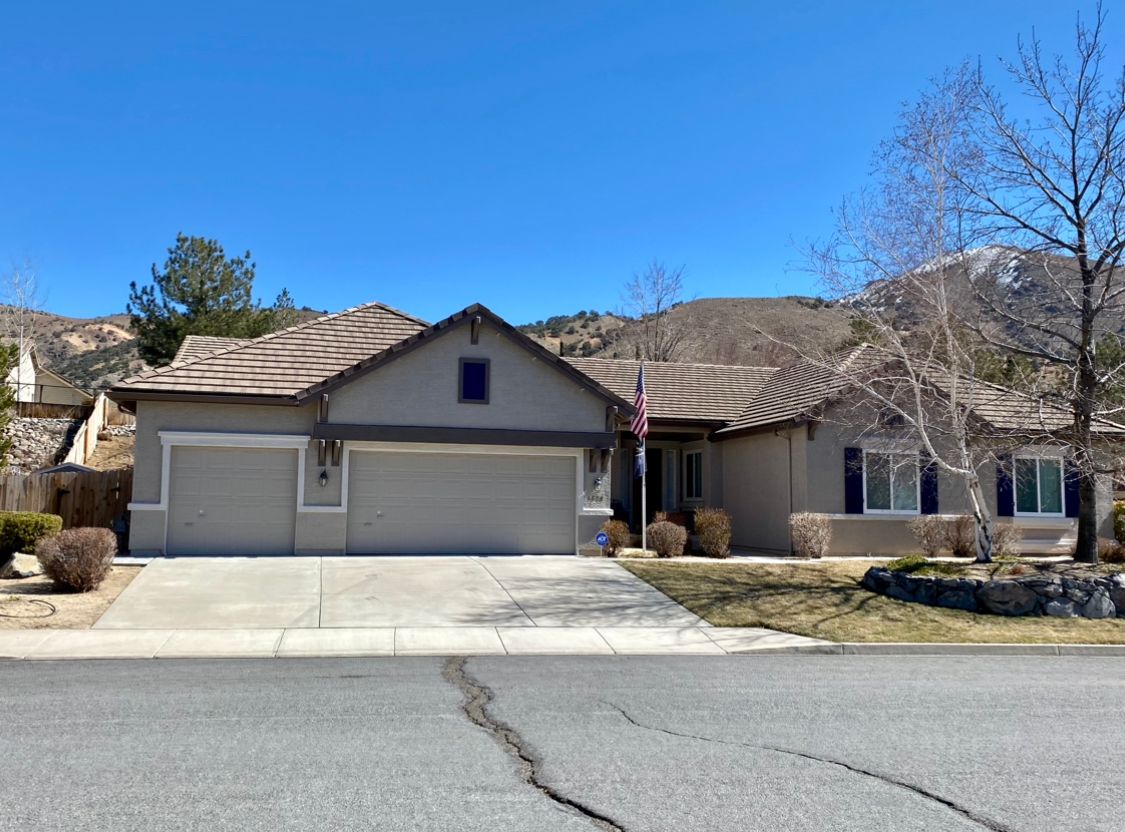 A house with two garage doors and a flag in front of it.