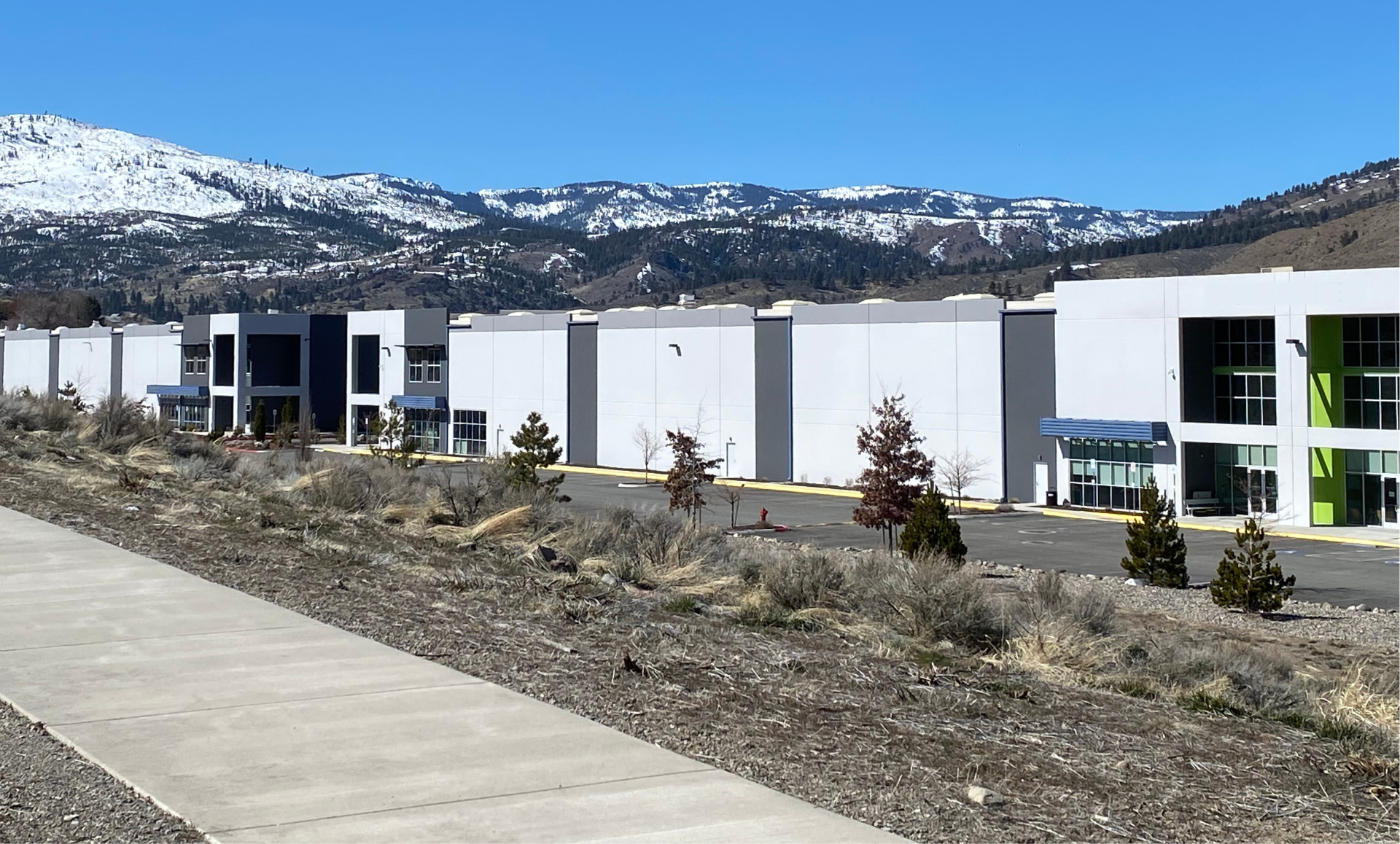 A row of white buildings with mountains in the background