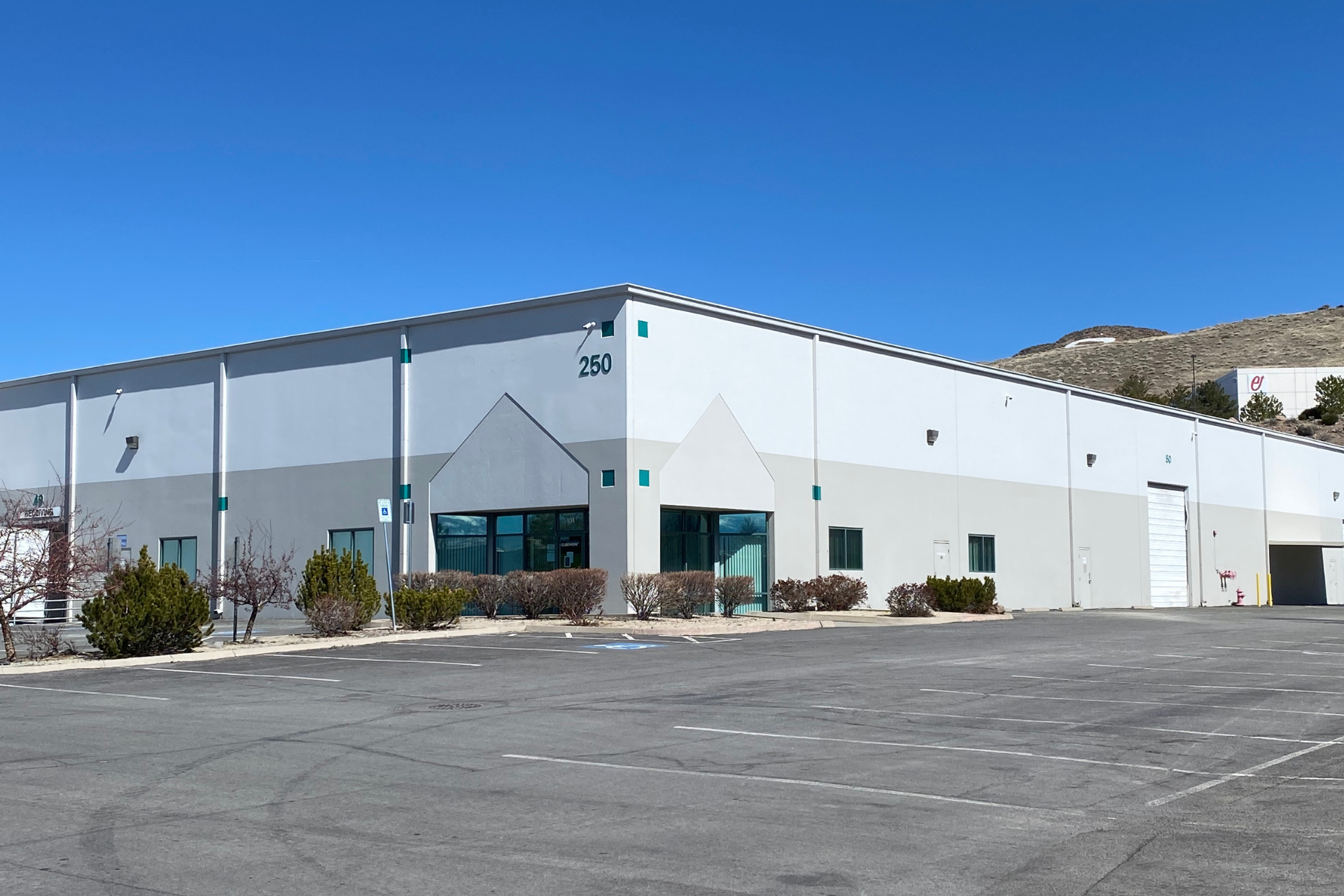 A large white building with a parking lot in front of it