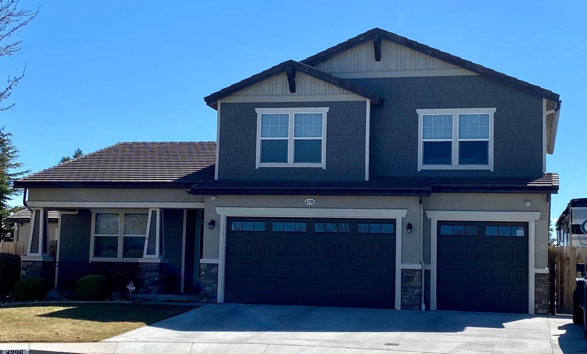 A large house with two garages and a car parked in front of it.