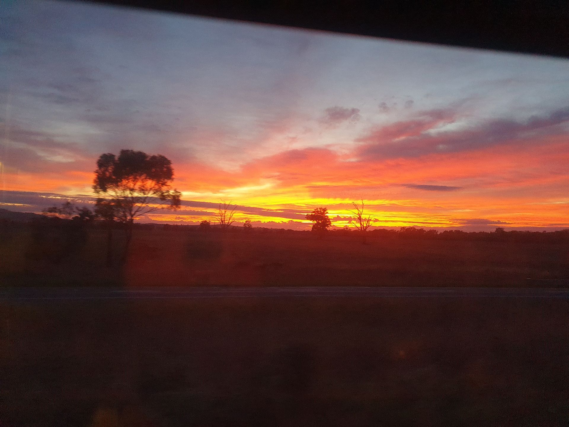 A train is going down the tracks in a field.