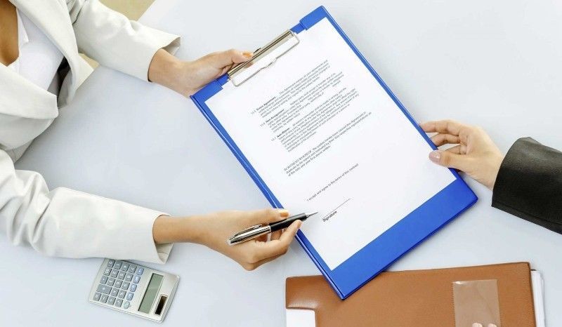 A person is holding a tablet with a graph on it.