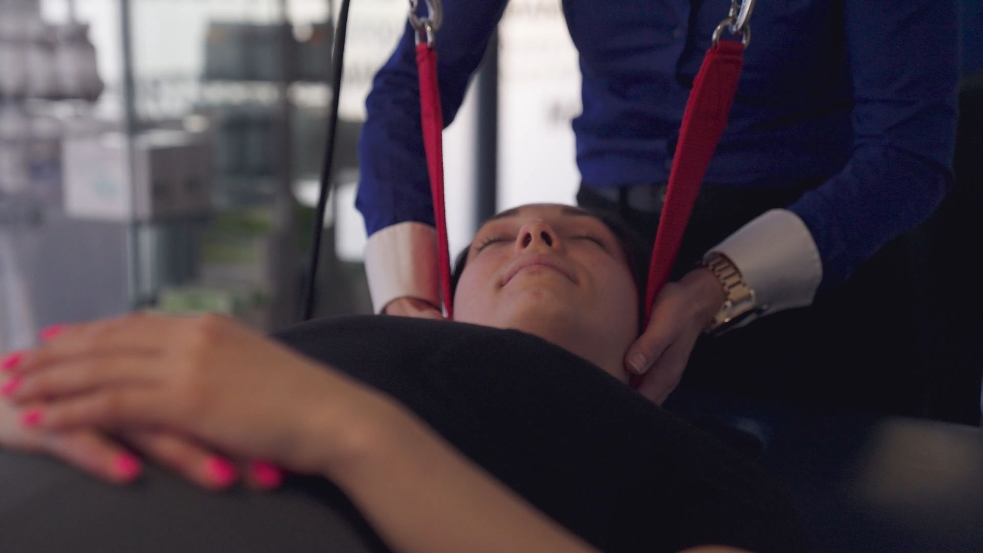 A woman is laying on a bed receiving an adjustment