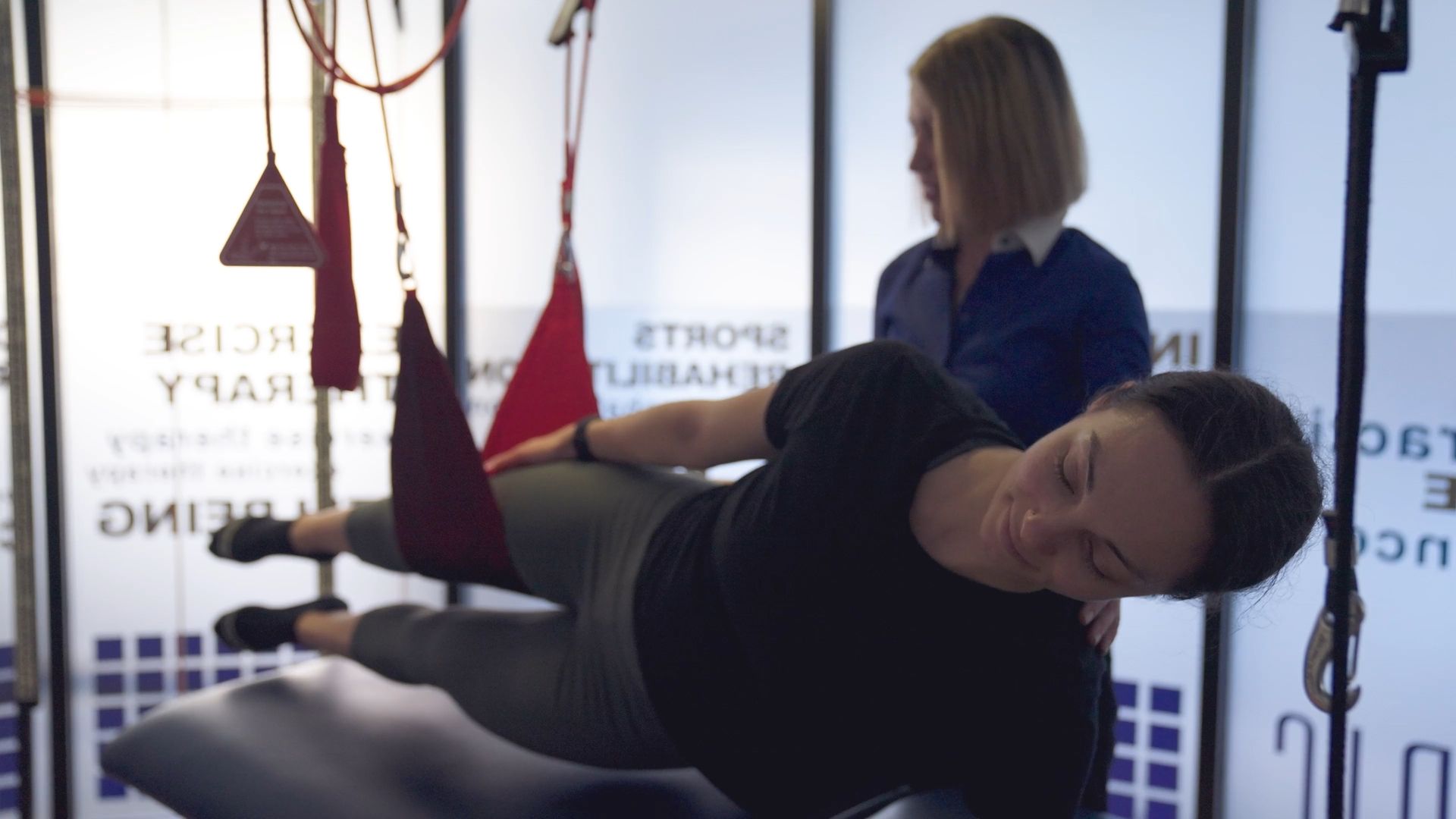 A woman is laying on a bed receiving an adjustment