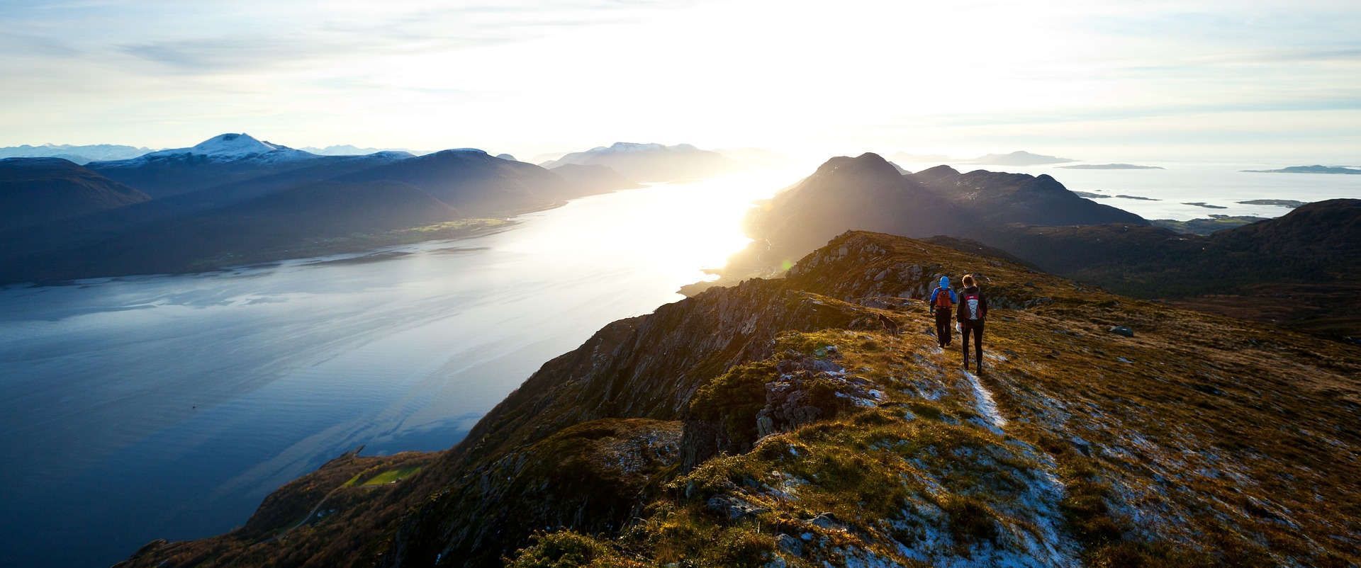 A silhouette of a man standing on top of a mountain