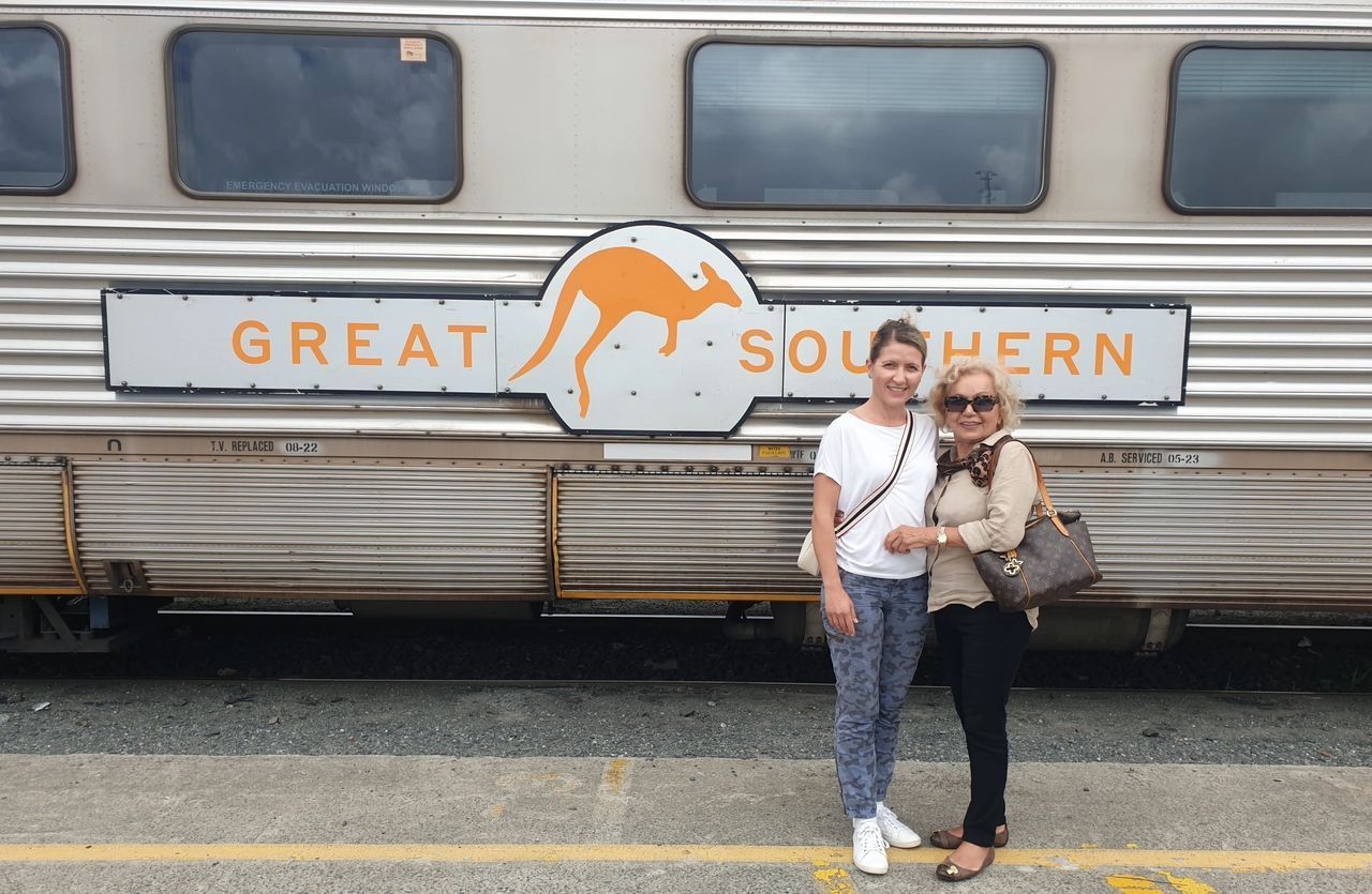 Two women standing in front of a great southern train