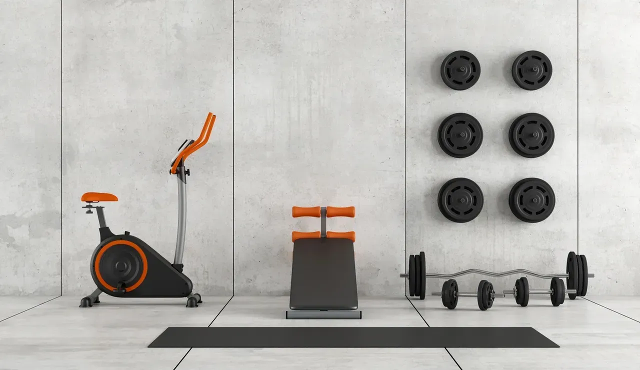 A gym with exercise bikes , dumbbells , and a mat.