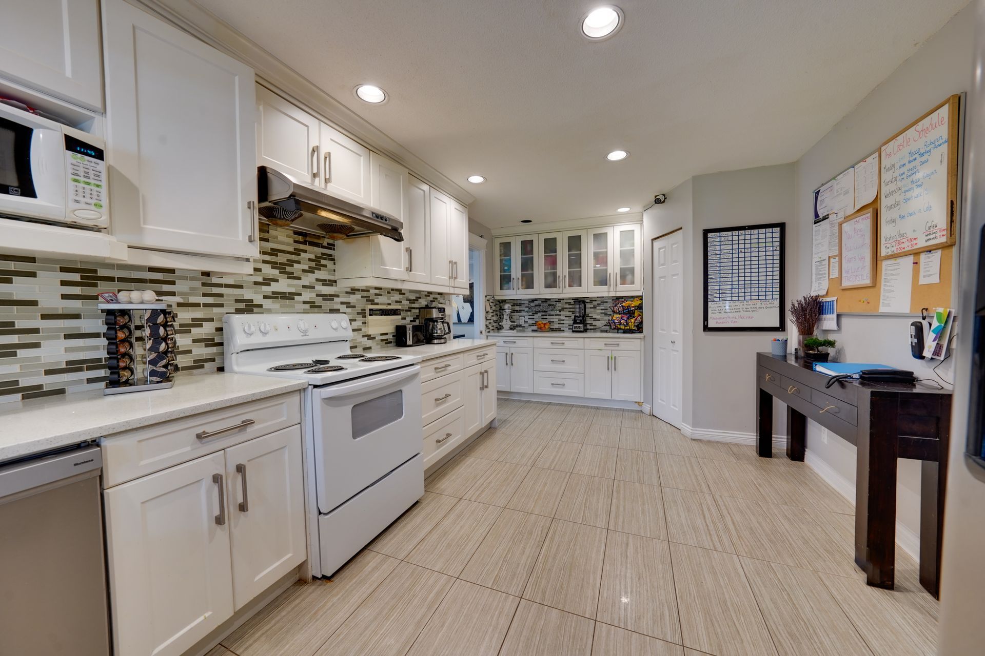 A kitchen with white cabinets and stainless steel appliances