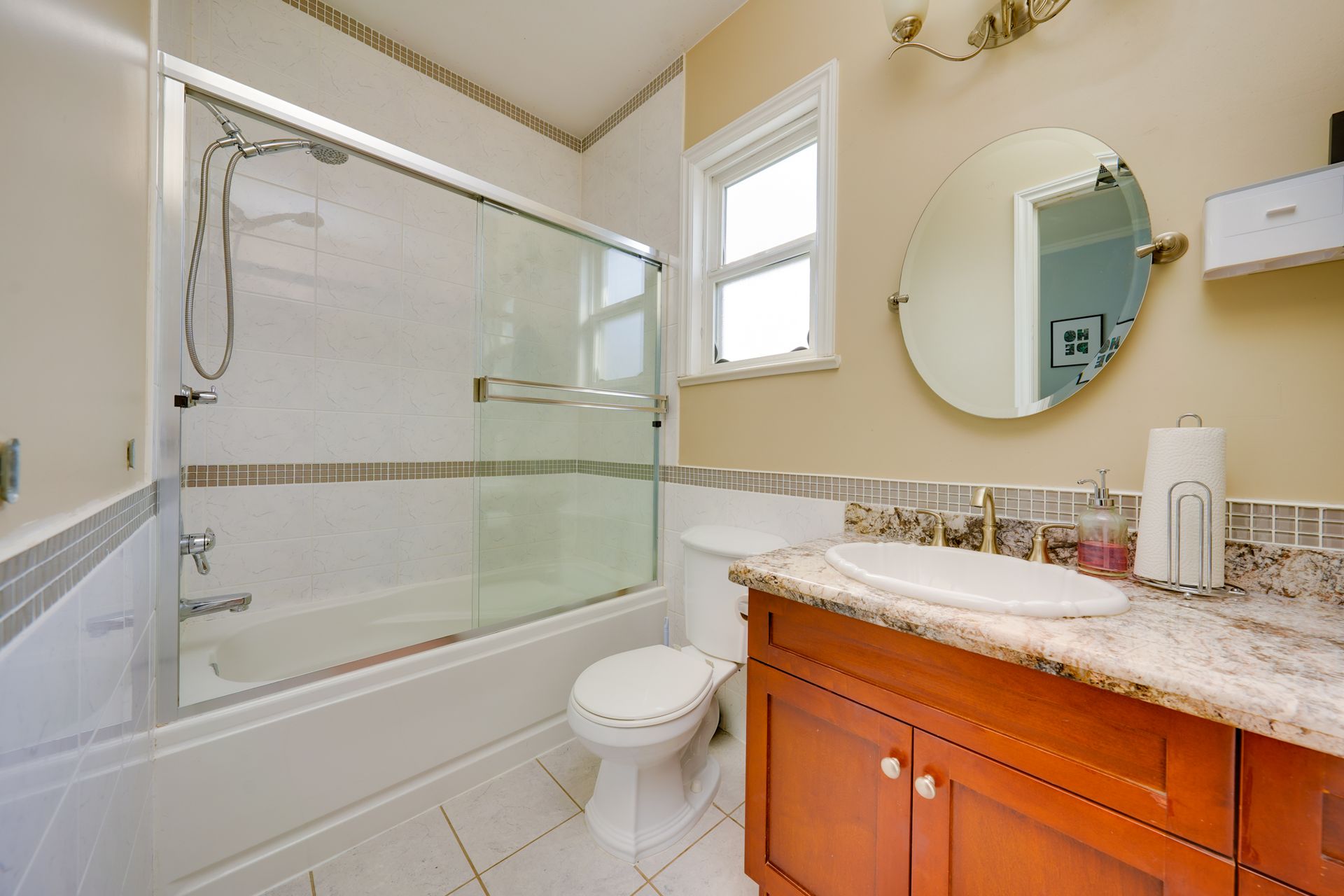 A bathroom with a toilet , sink , shower and mirror