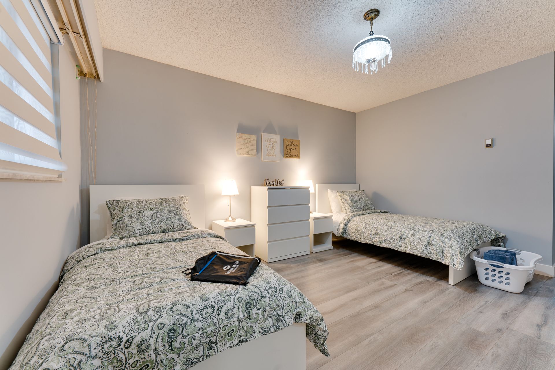 A bedroom with two beds and a laundry basket