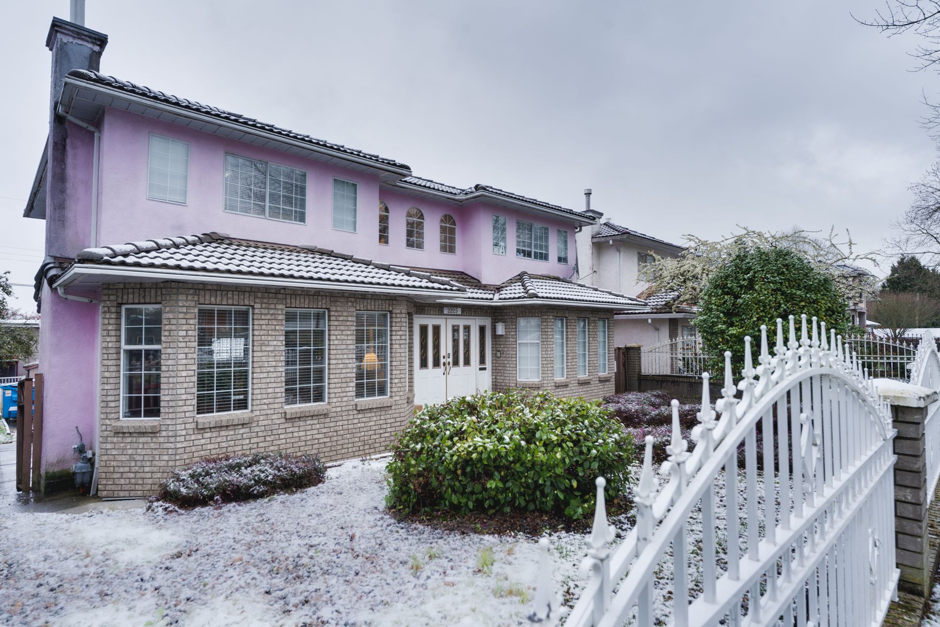 A house with a walkway leading to it and a palm tree in front of it.