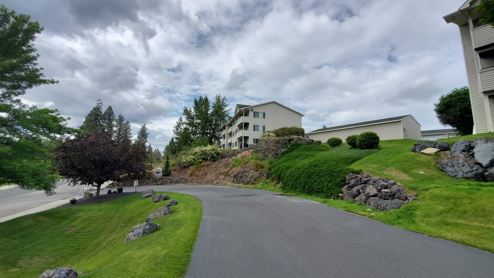 A road going through a residential area with a building in the background.