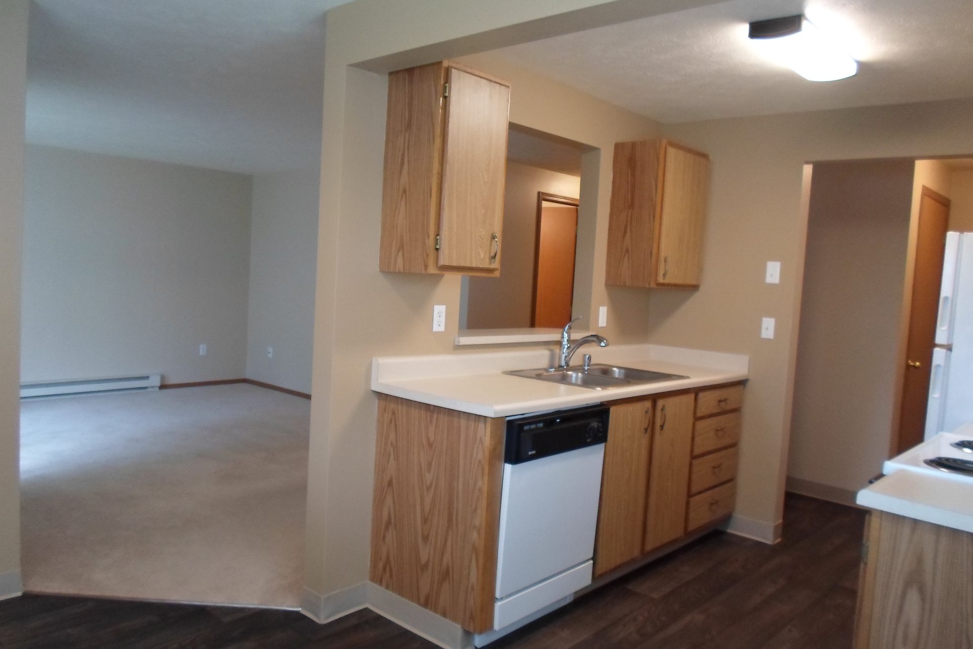 A kitchen with wooden cabinets and a white dishwasher