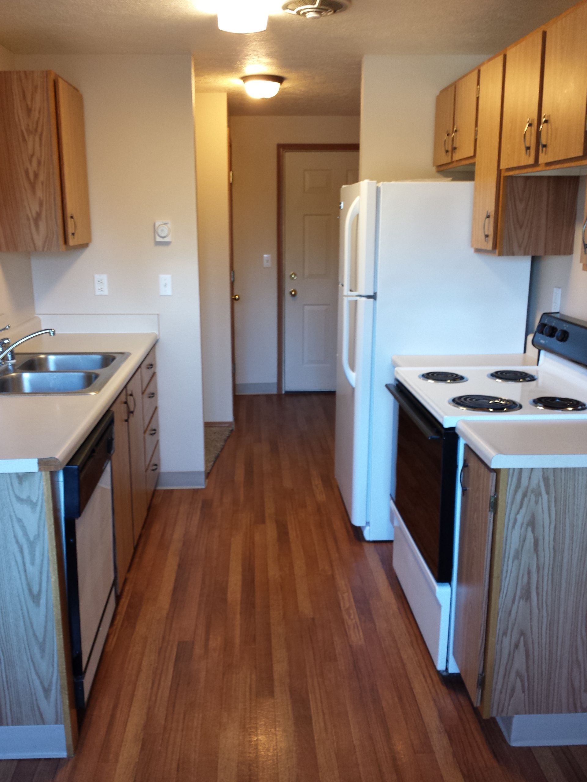 A kitchen with a stove a refrigerator and a sink