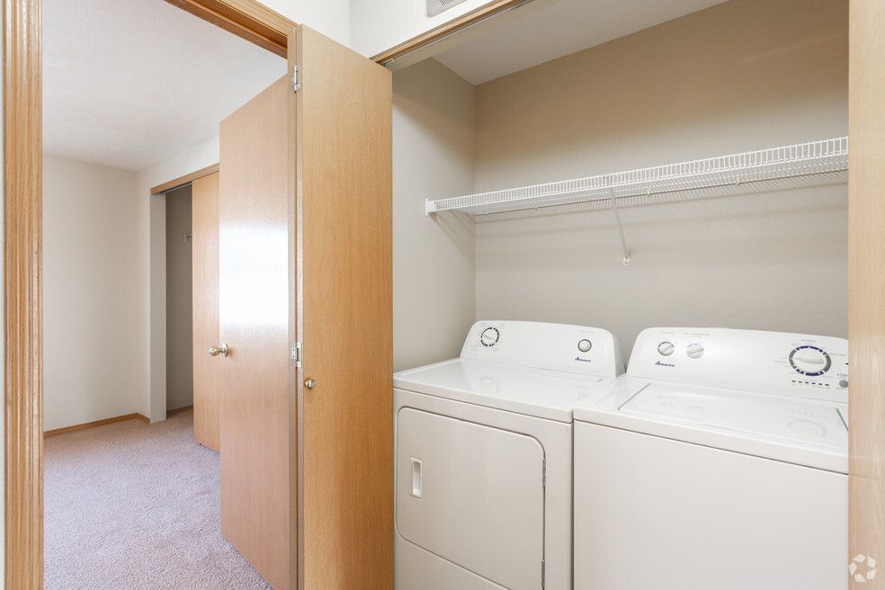 A washer and dryer are in a closet in a house.