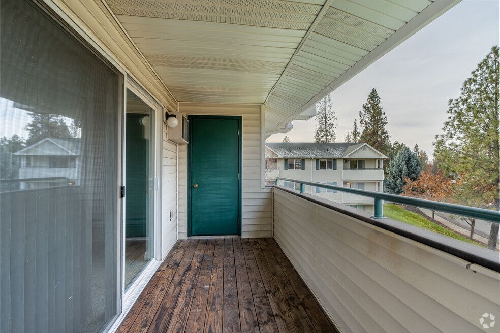 A balcony with sliding glass doors and a green door