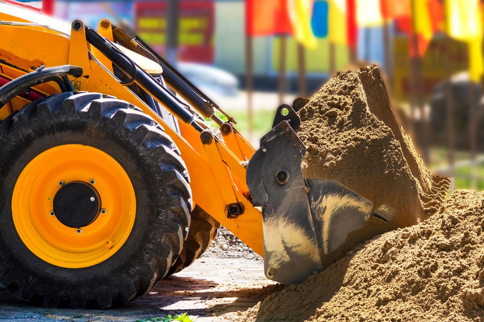 Yellow Backhoe Loader Scooping a Pile of Dirt on a Construction Site — Environment Restoration Solutions in Tweed Heads, NSW