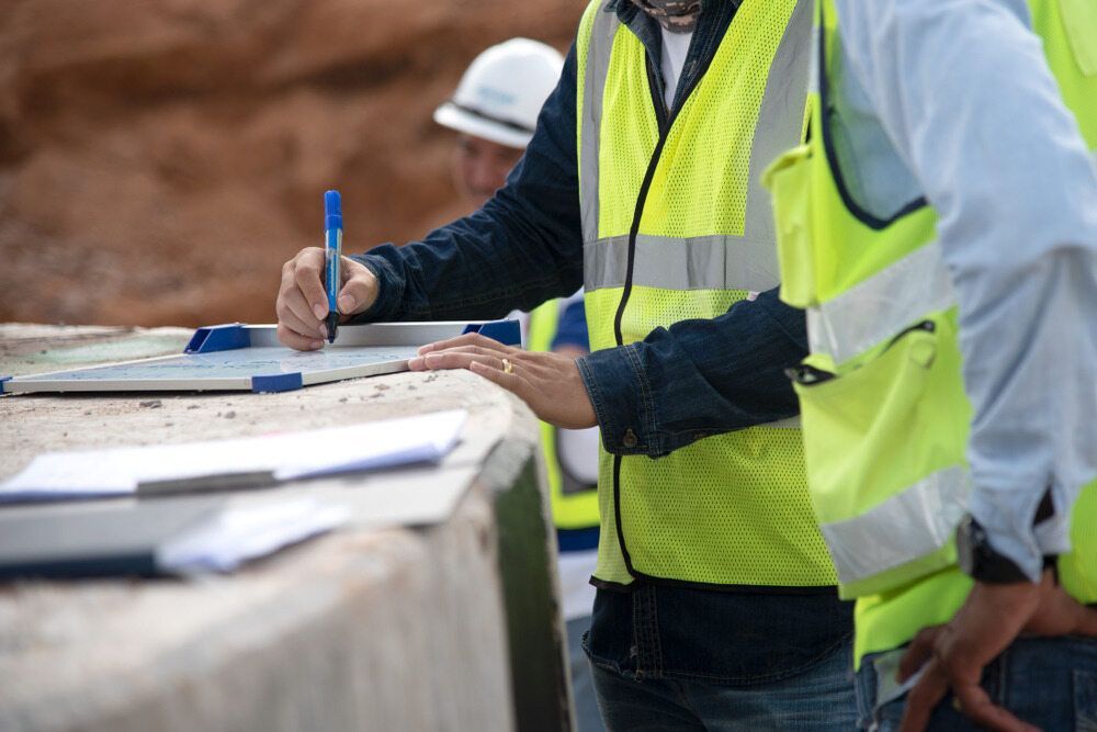 Construction Workers in High-visibility Vests Reviewing Blueprints — Environment Restoration Solutions in Tweed Heads, NSW