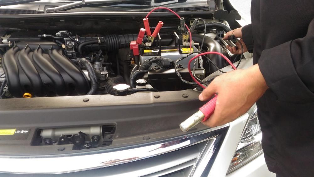 A Person Is Charging a Car Battery with A Charger — Belmont Auto Electrics in Belmont, NSW