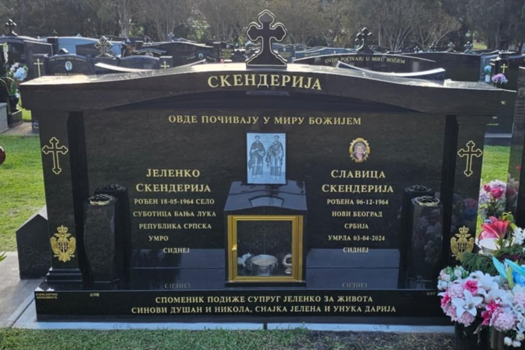 Black granite Skenderija family tombstone in a cemetery.