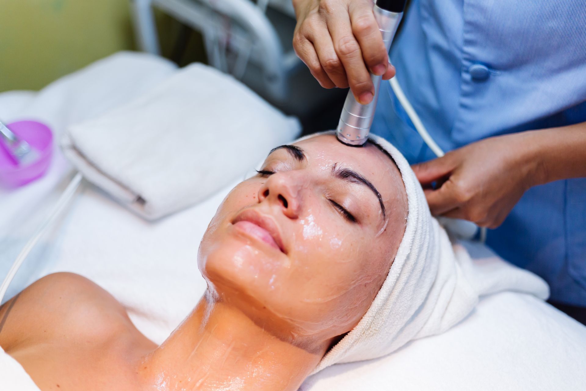 A woman is getting a facial treatment at a beauty salon.