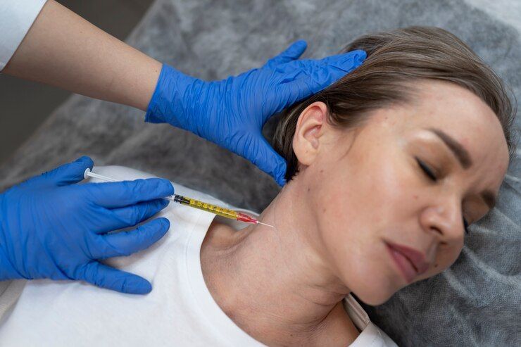 A woman is getting a botox injection in her neck.