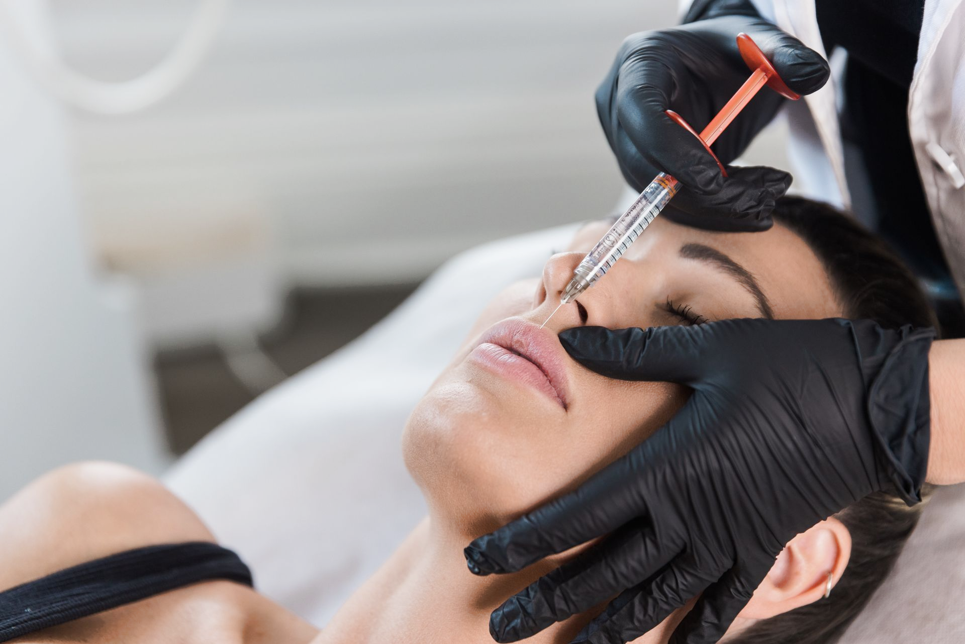 A woman is getting a botox injection in her nose.