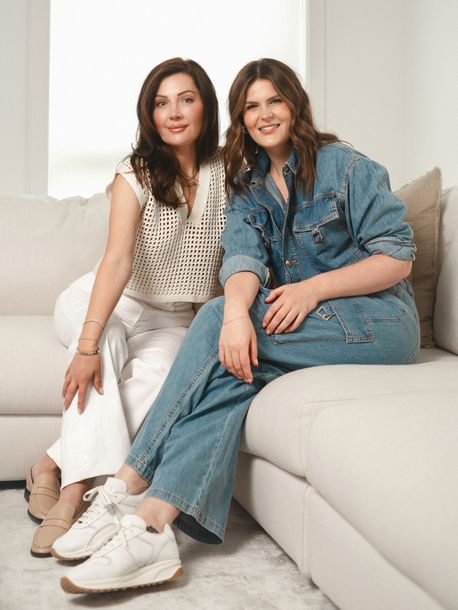 Two women are standing next to each other with their arms crossed.