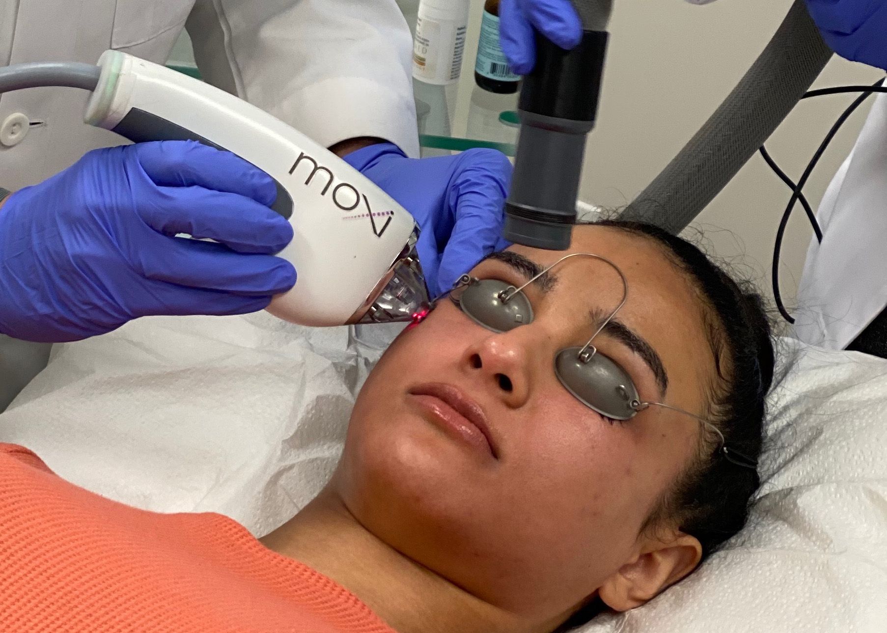 A woman is getting a laser treatment on her face.