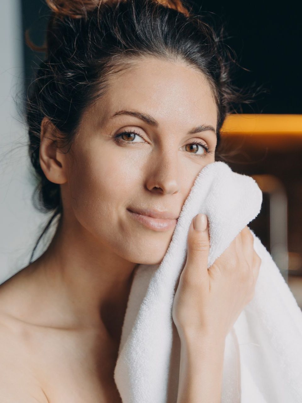 woman wiping face with towel