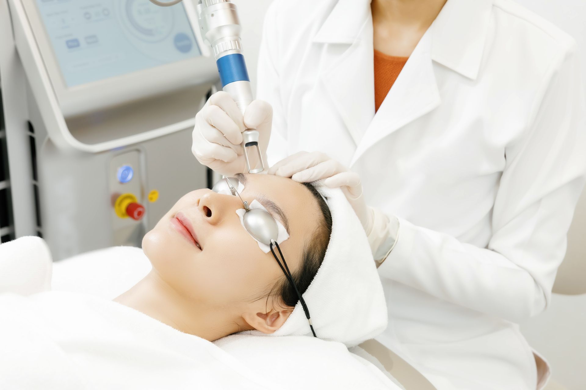 A woman is getting a laser treatment on her face.