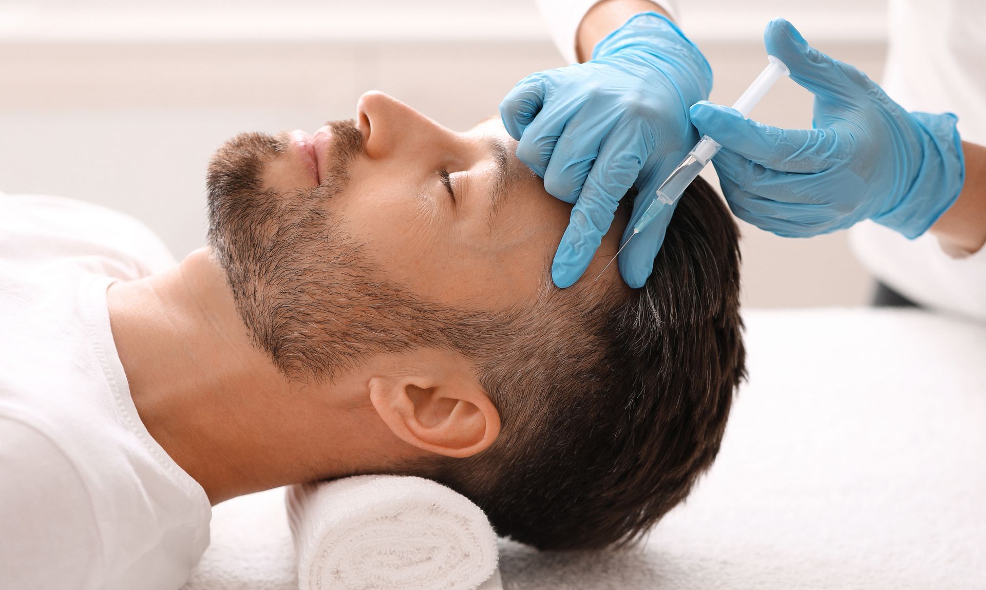 A man is getting an injection in his head in a beauty salon.