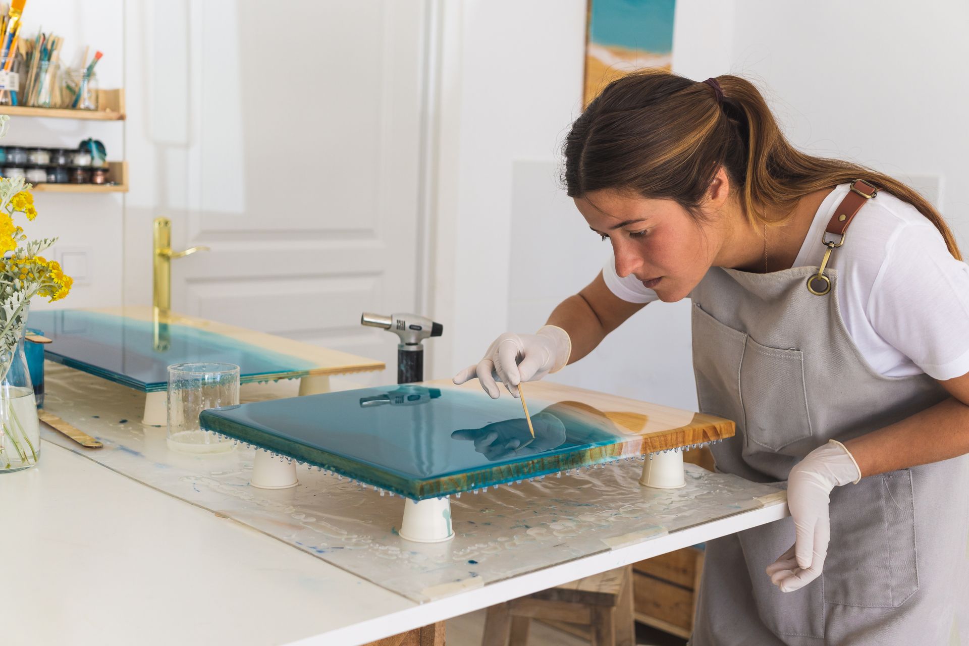 A woman is painting a picture on a table.