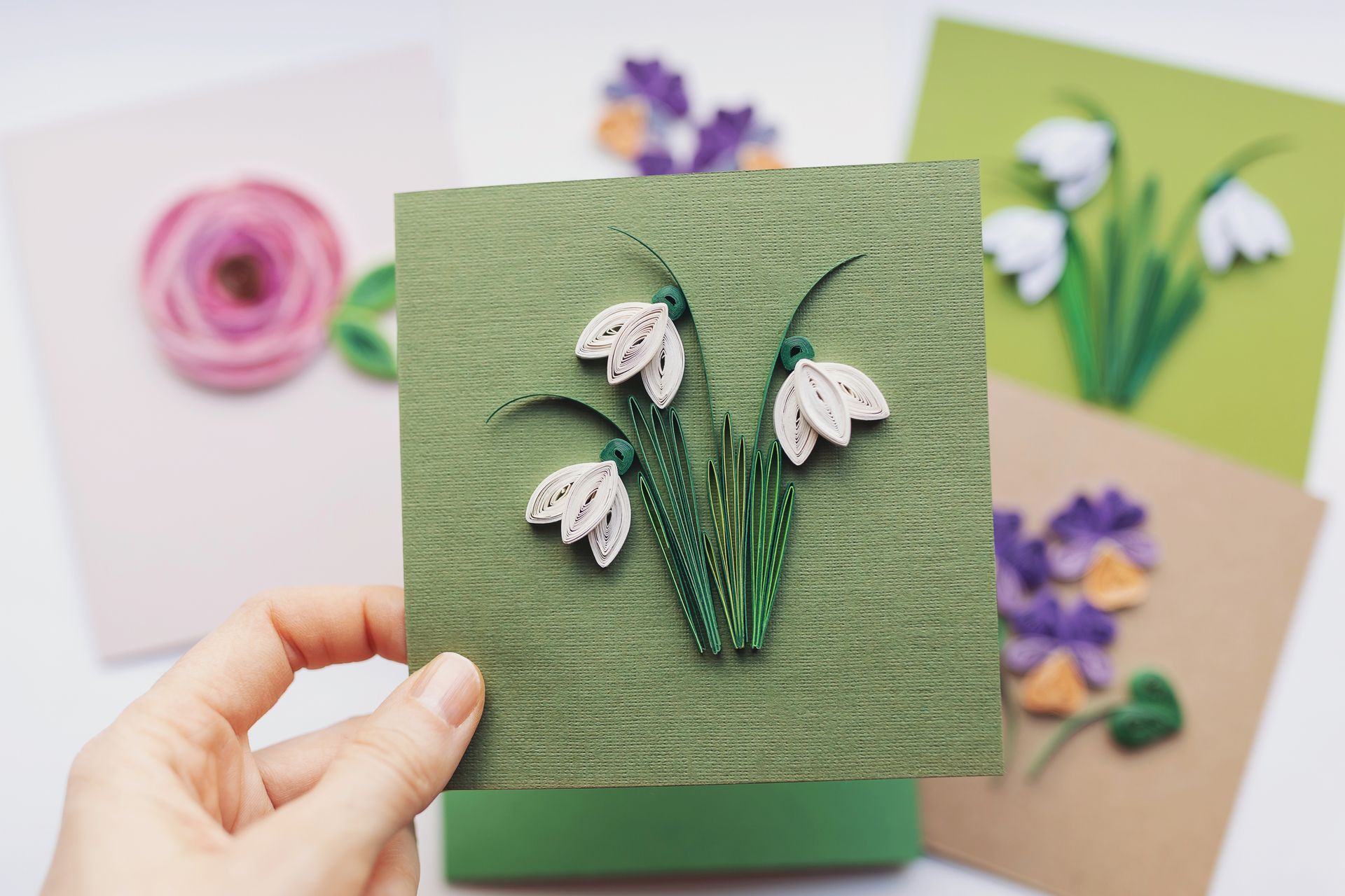 A person is holding a card with flowers on it.
