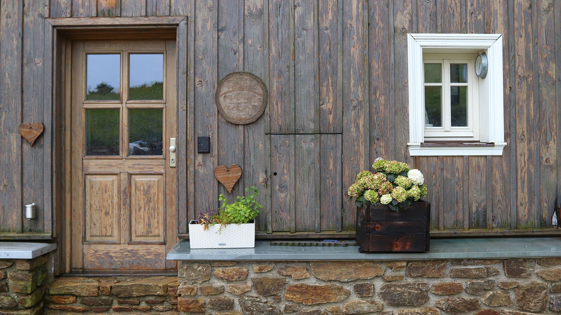 Spacious living room with hardwood floors, sofa, windows, and opening to another room.