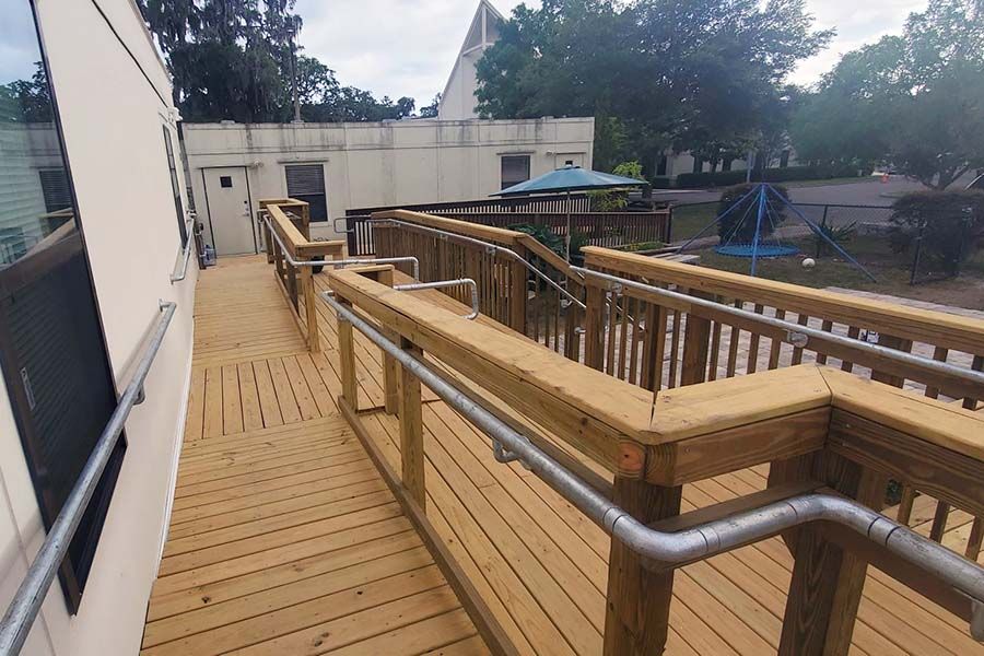 Wooden ramp with metal handrails outside a building.