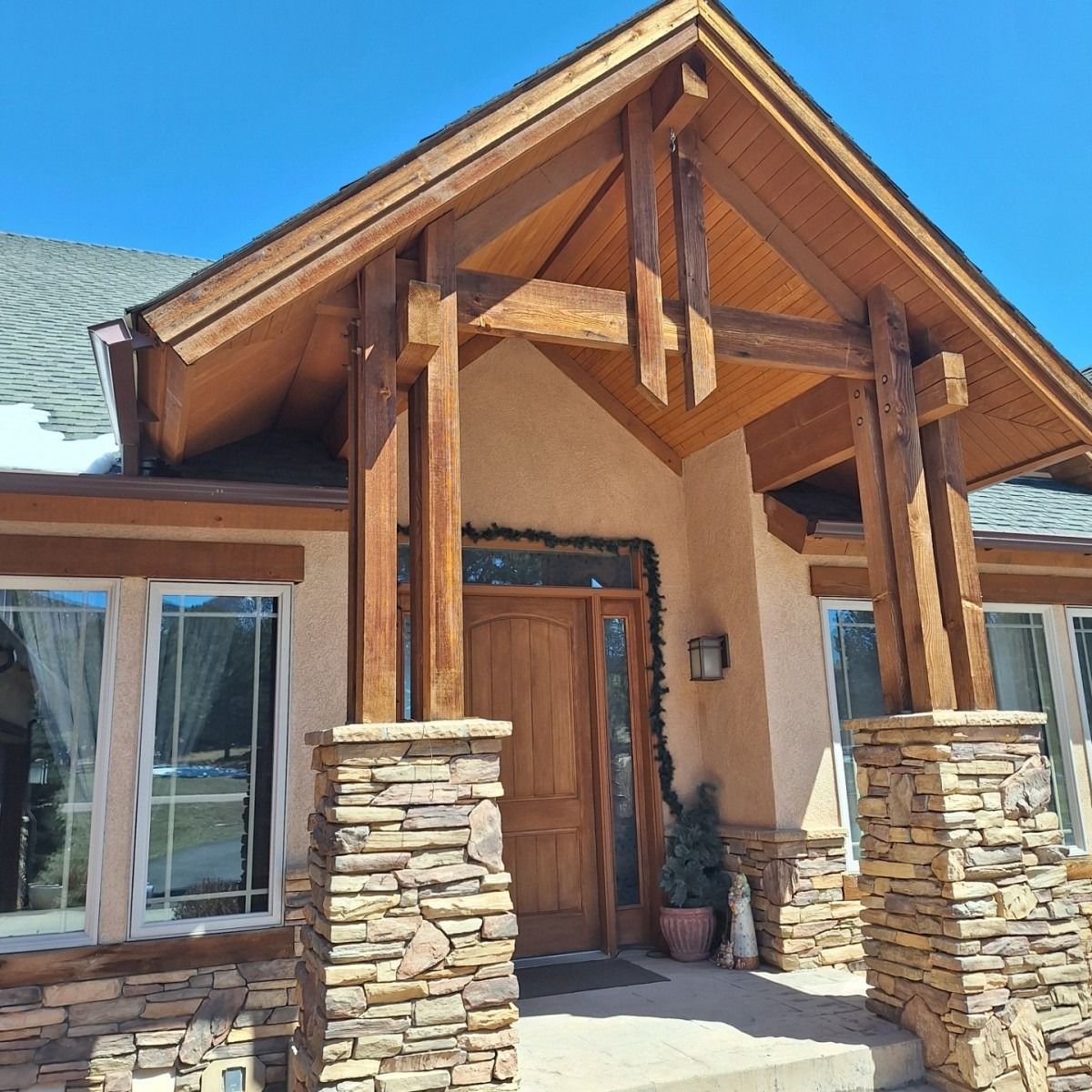 Modern living room with tan sofa, fireplace, and staircase.