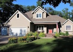 Modern living room with blue accent wall, built-in TV unit, and yellow armchair.