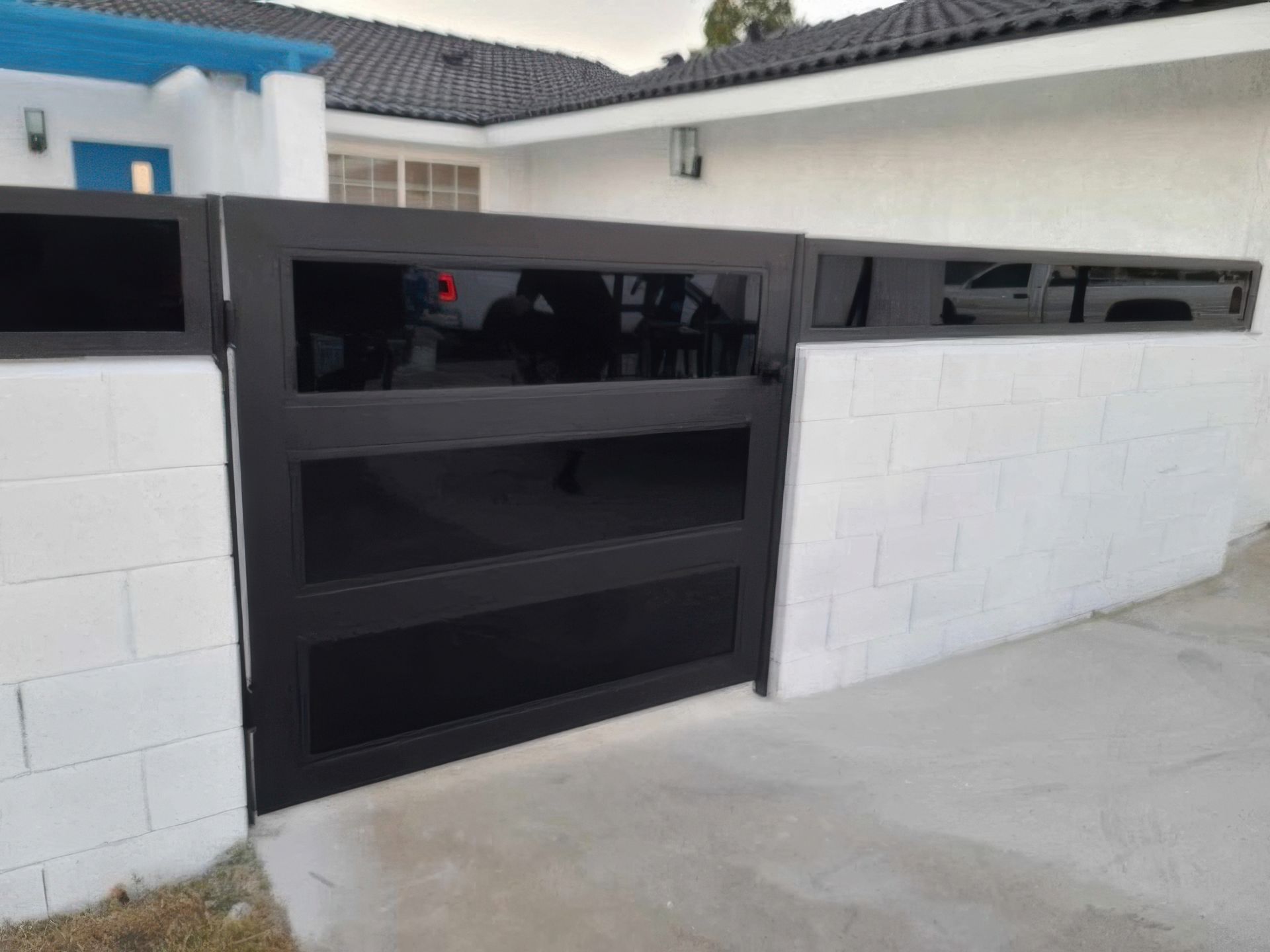 A white house with a black gate in front of it