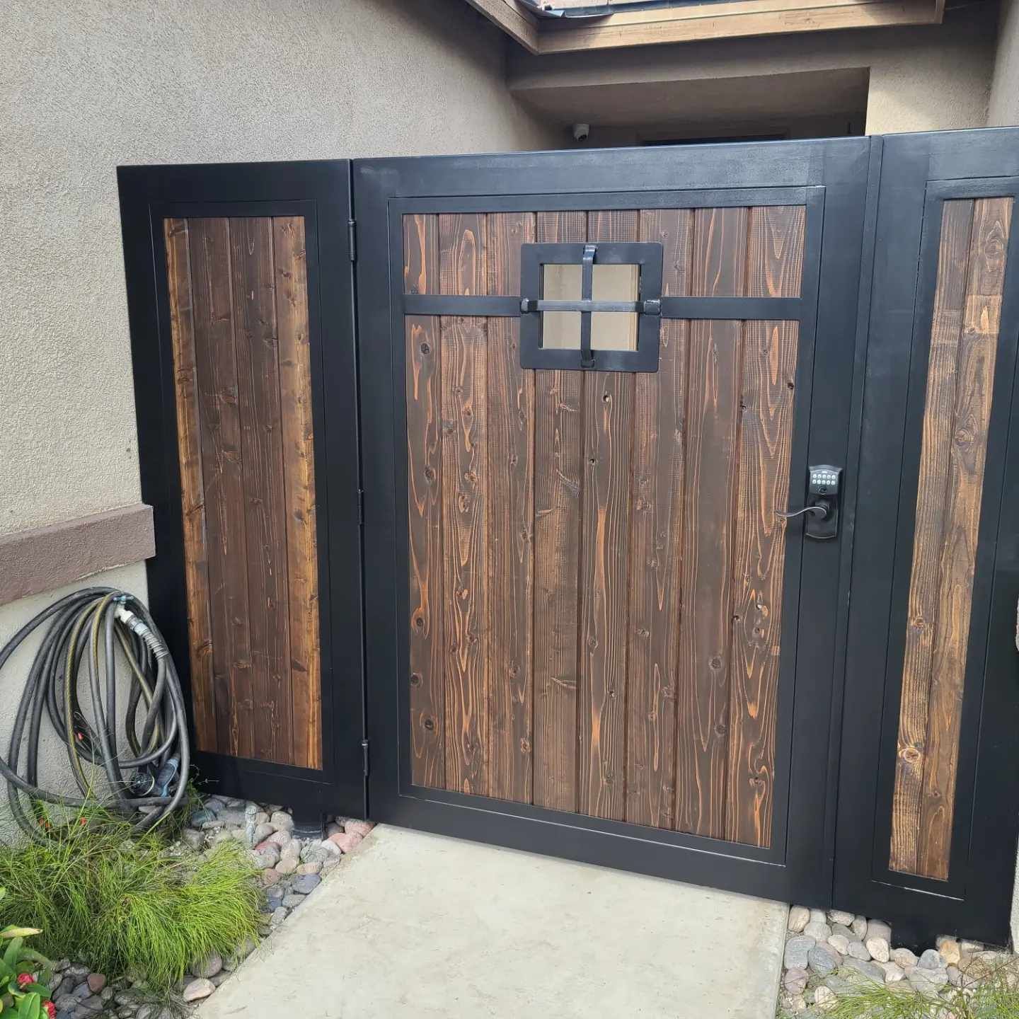 A wooden gate with a black frame and a window