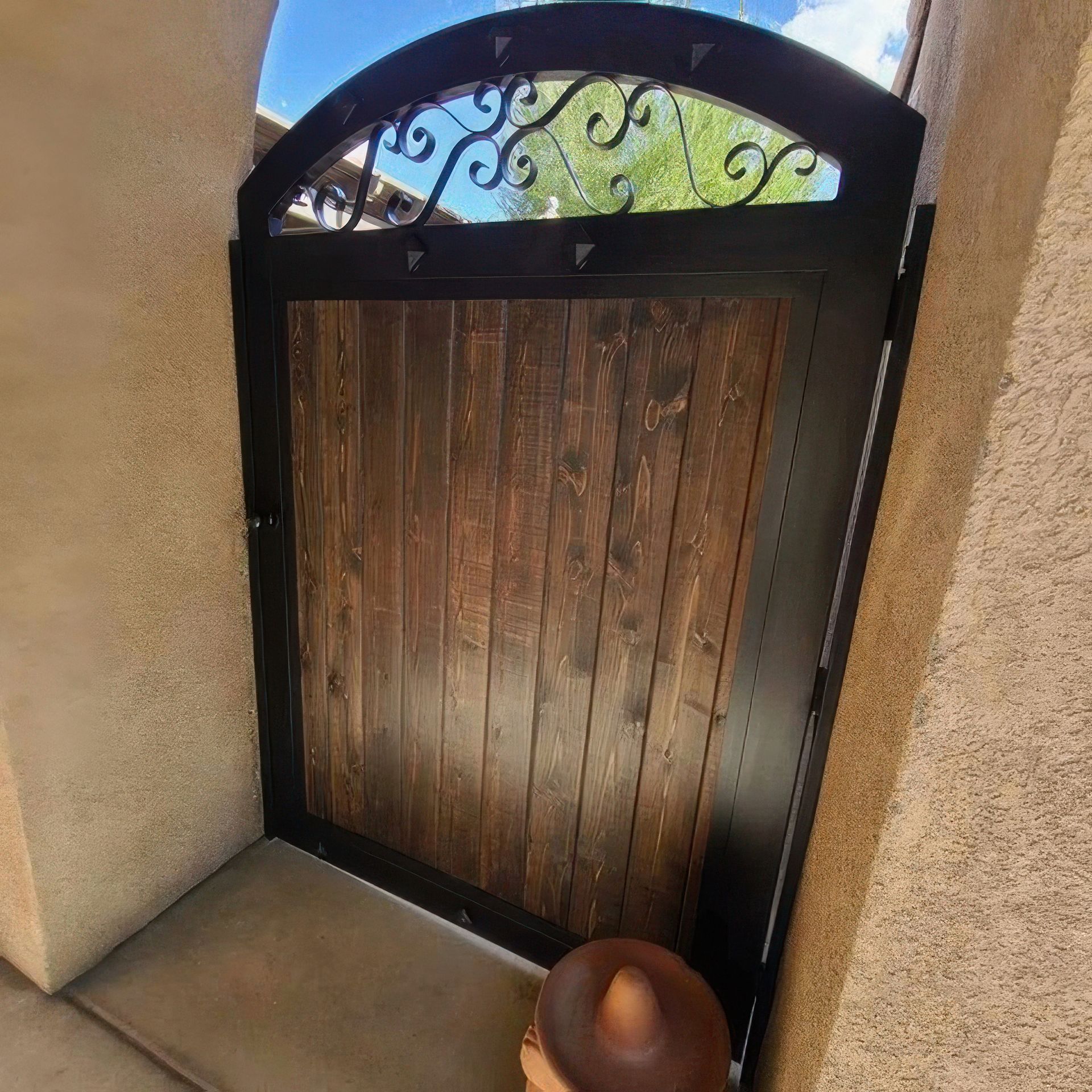 A wooden gate with a wrought iron design on it