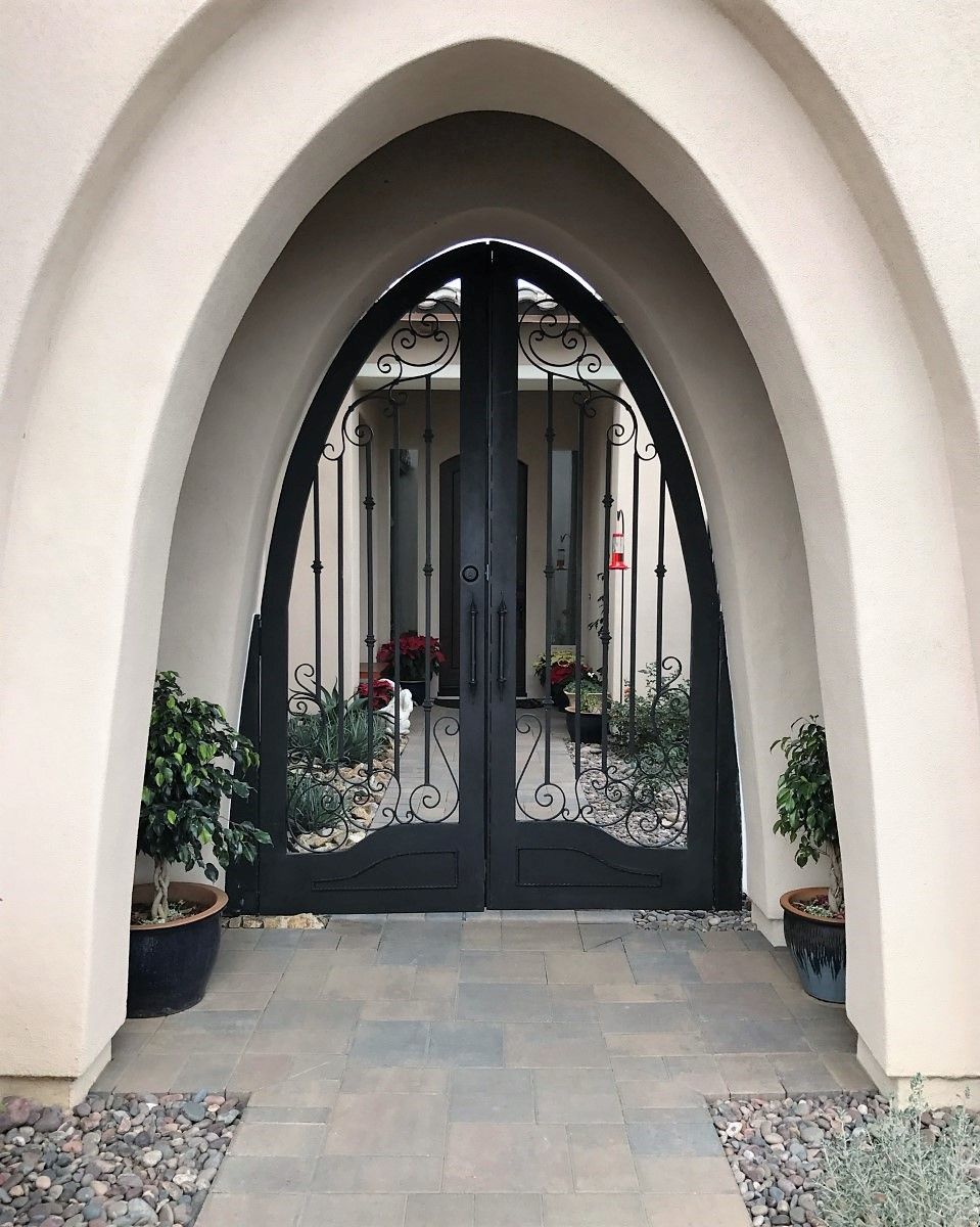 A large arched doorway with a few potted plants in front of it