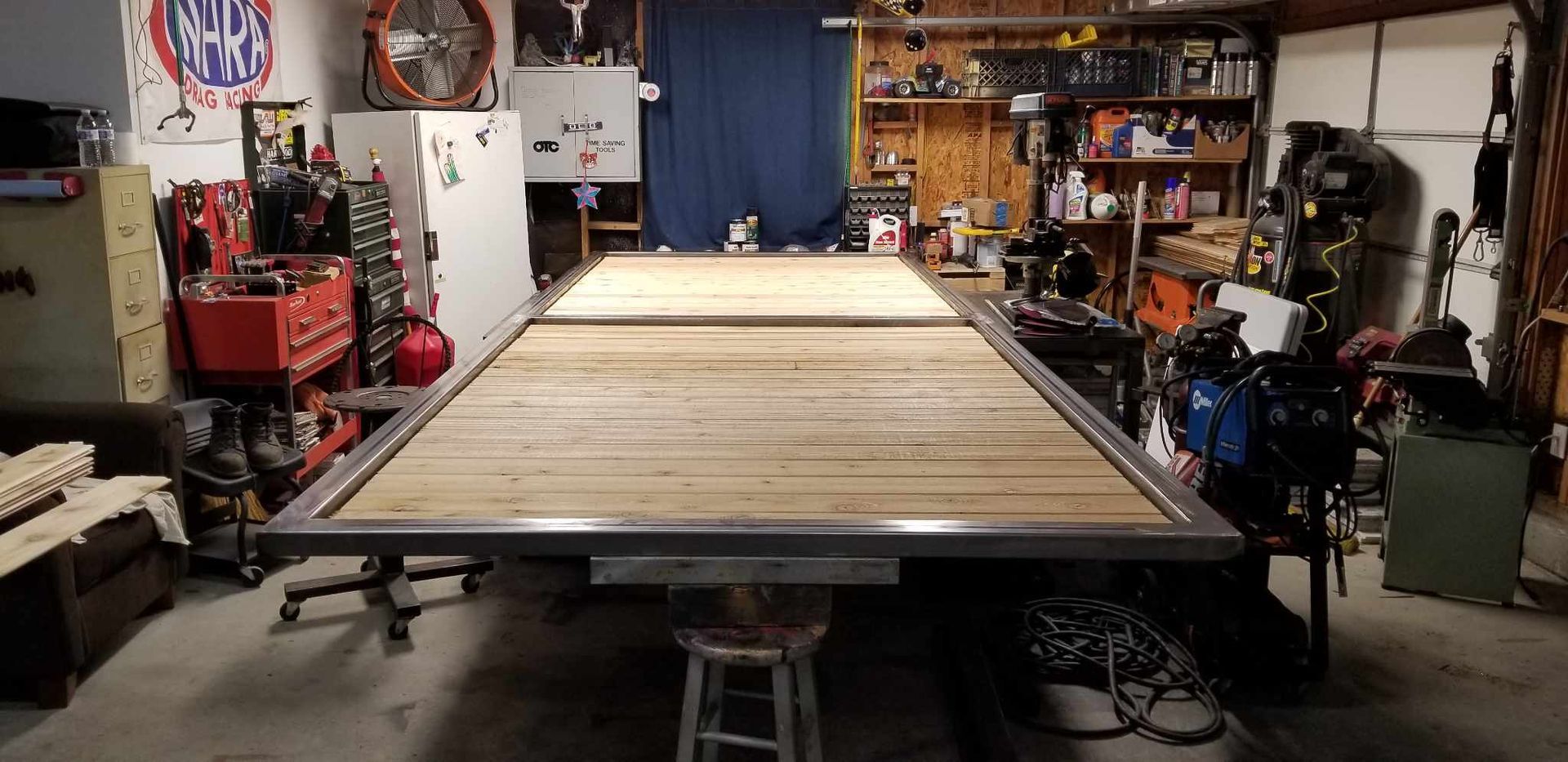 There is a large wooden table in the middle of a garage.