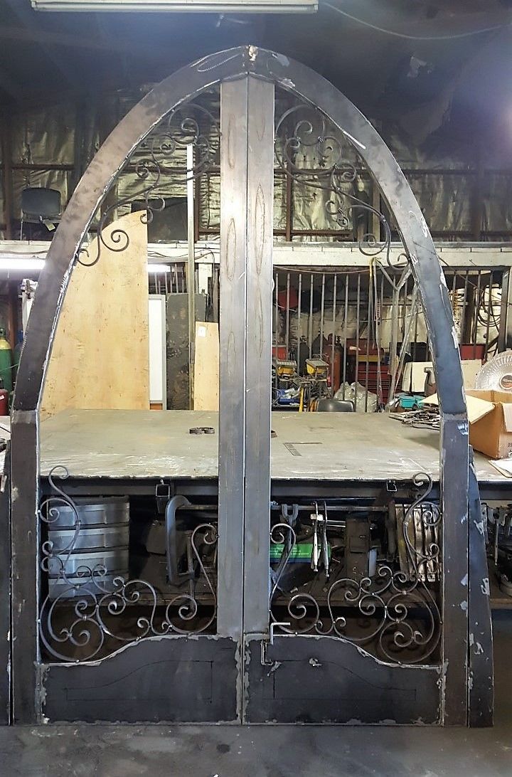 A wrought iron gate is sitting on a table in a workshop.