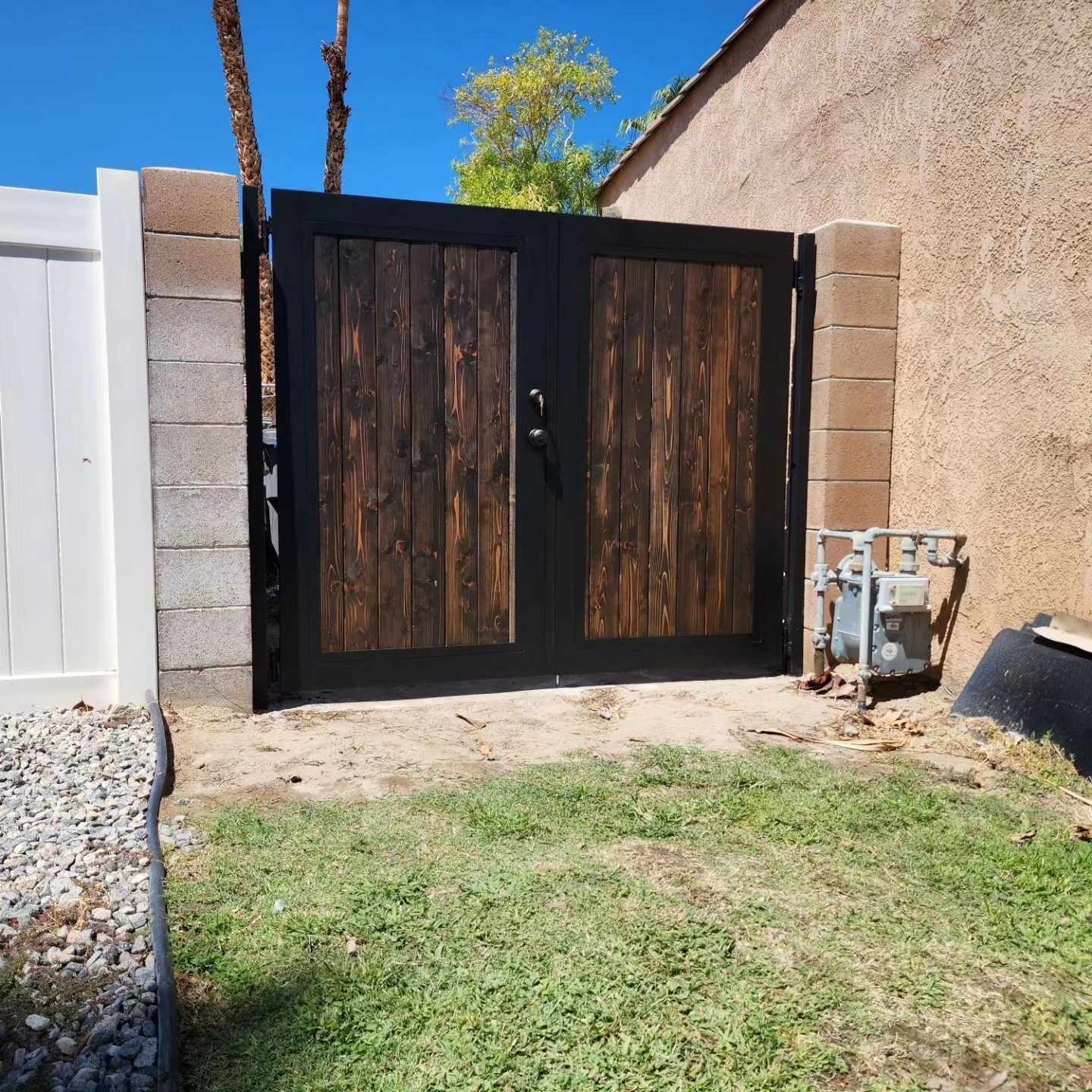 A fence with a wooden gate and a white fence behind it